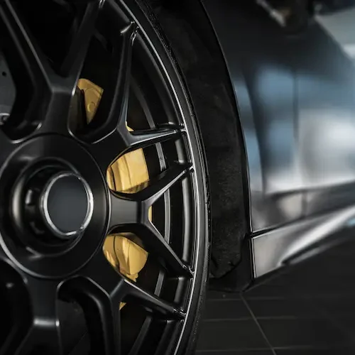 closeup-of-sleek-black-car-wheel-in-garage-2026-03-24-03-57-25-utc